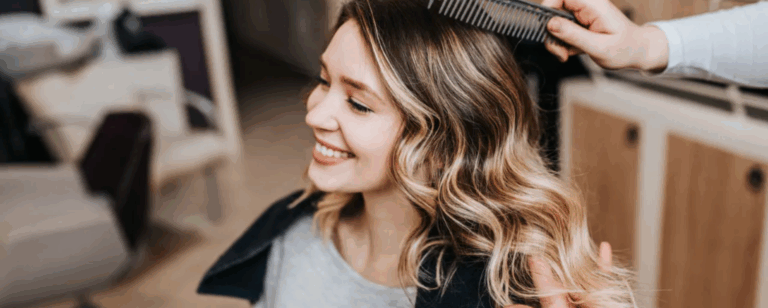 Estilista aplicando foilayage en secciones de cabello castaño