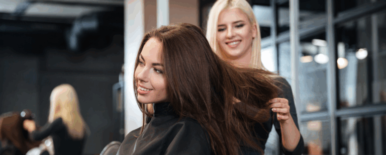 Estilista trabajando con el cabello de una clienta en salón de belleza